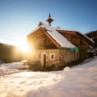 Die Kärntner Sandrisserhütte im Sonnenuntergang | © Urlaub am Bauernhof Kärnten / Daniel Gollner