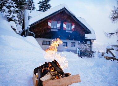 Feuerstelle im Schnee vor der Almhütte | © Urlaub am Bauernhof Kärnten/ Daniel Gollner