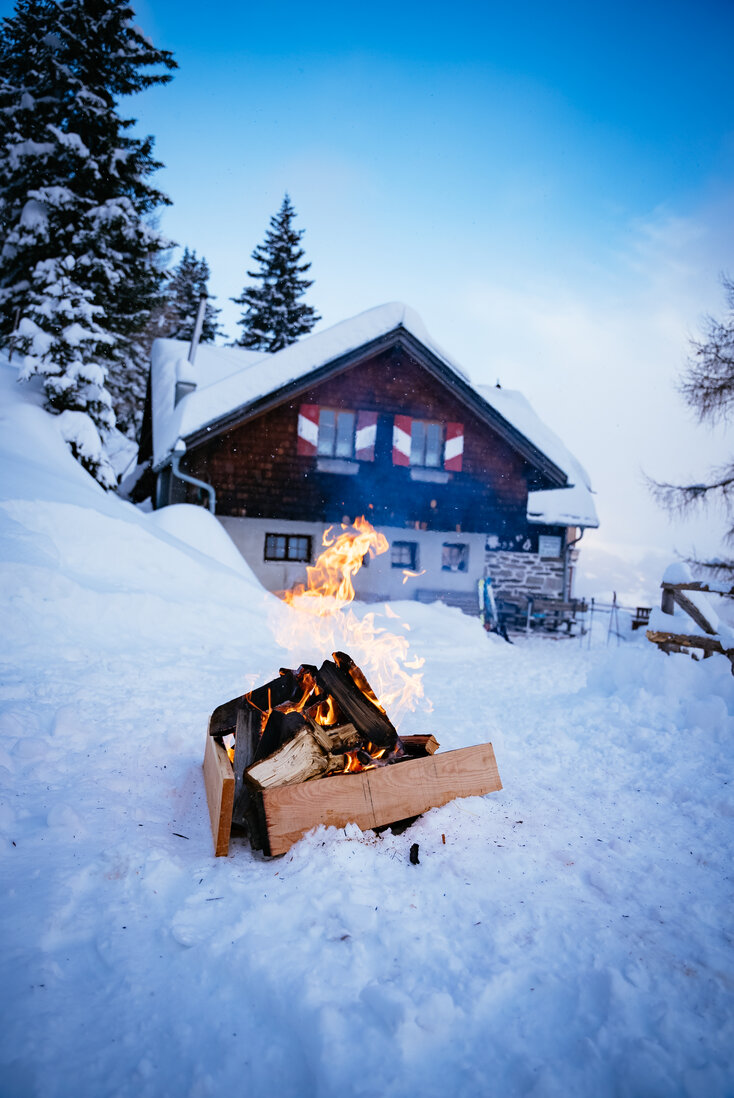 Feuerstelle im Schnee vor der Almhütte | © Urlaub am Bauernhof Kärnten/ Daniel Gollner