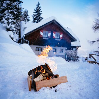 Feuerstelle im Schnee vor der Almhütte | © Urlaub am Bauernhof Kärnten/ Daniel Gollner