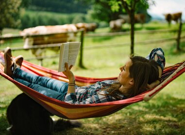 Frau liest Buch in der Hängematte / Urlaub am Bauernhof | © Daniel Gollner